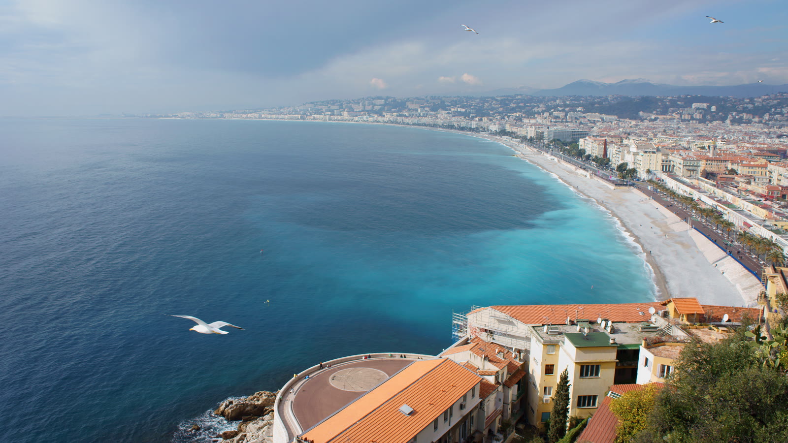 Udsigt fra slotsbakken over Baie des Anges med stranden og Promenade des Anglais i Nice