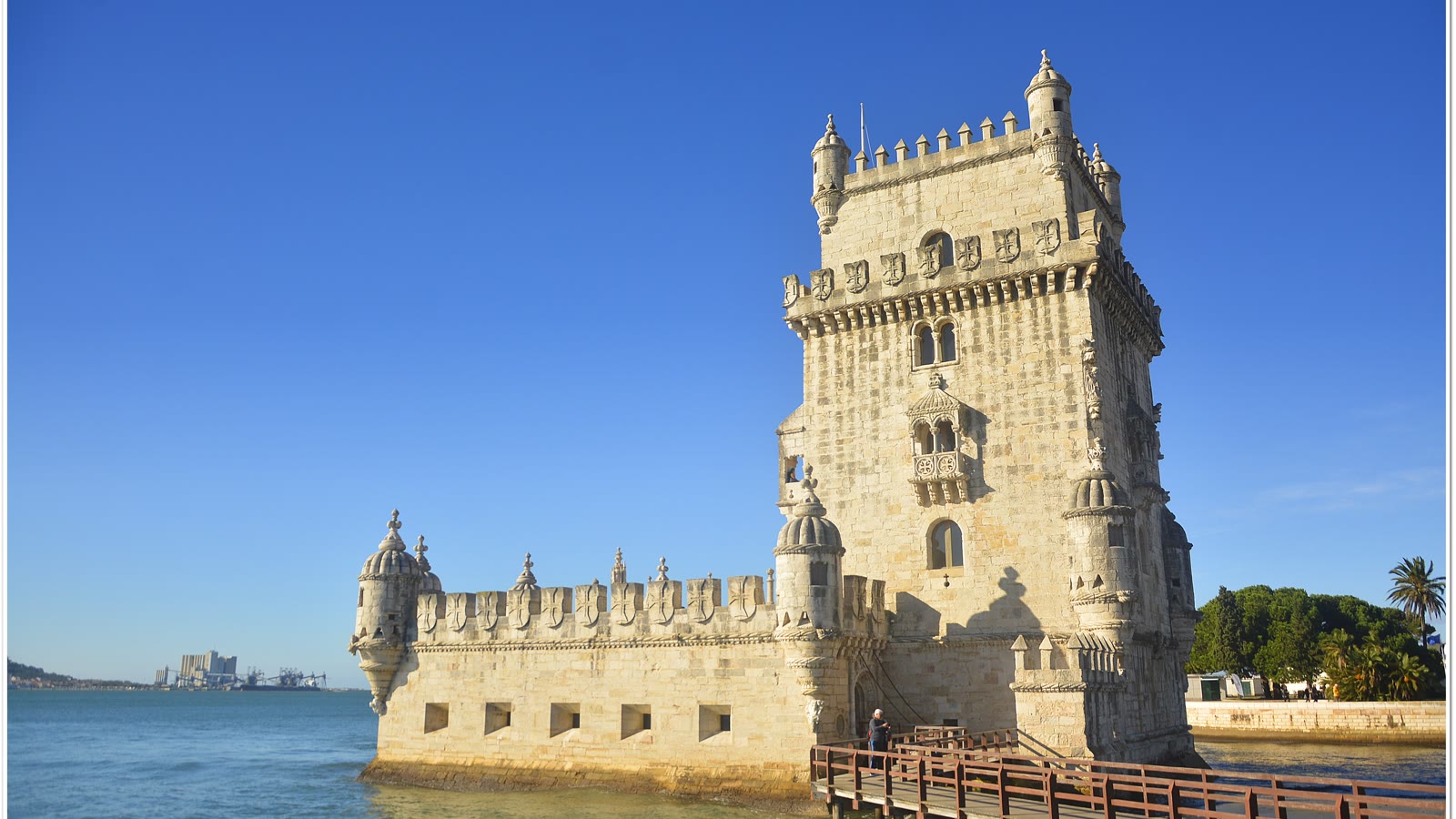 Torre de Belém i Lissabon set fra flodbredden med gangbroen ud til tårnet