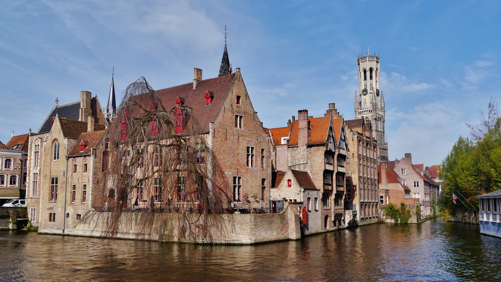 Kanalen ved Rozenhoedkaai i Brugge med gamle murstenshuse og klokketårnet Belfort i baggrunden