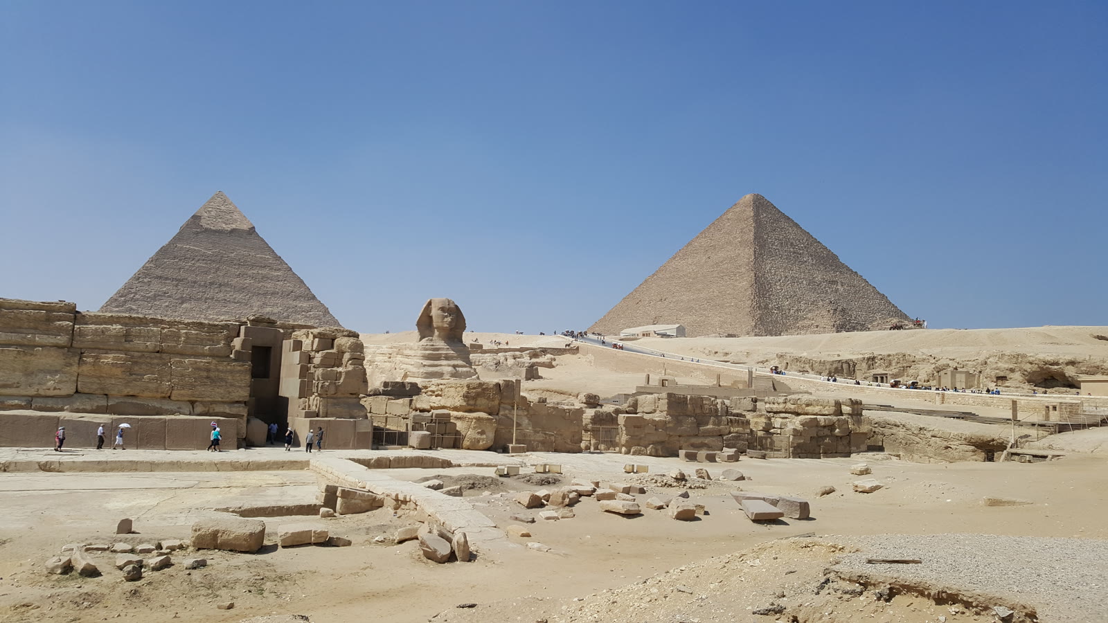 Sfinksen i Giza med Khefrens pyramide til venstre og Kheopspyramiden til højre under blå himmel