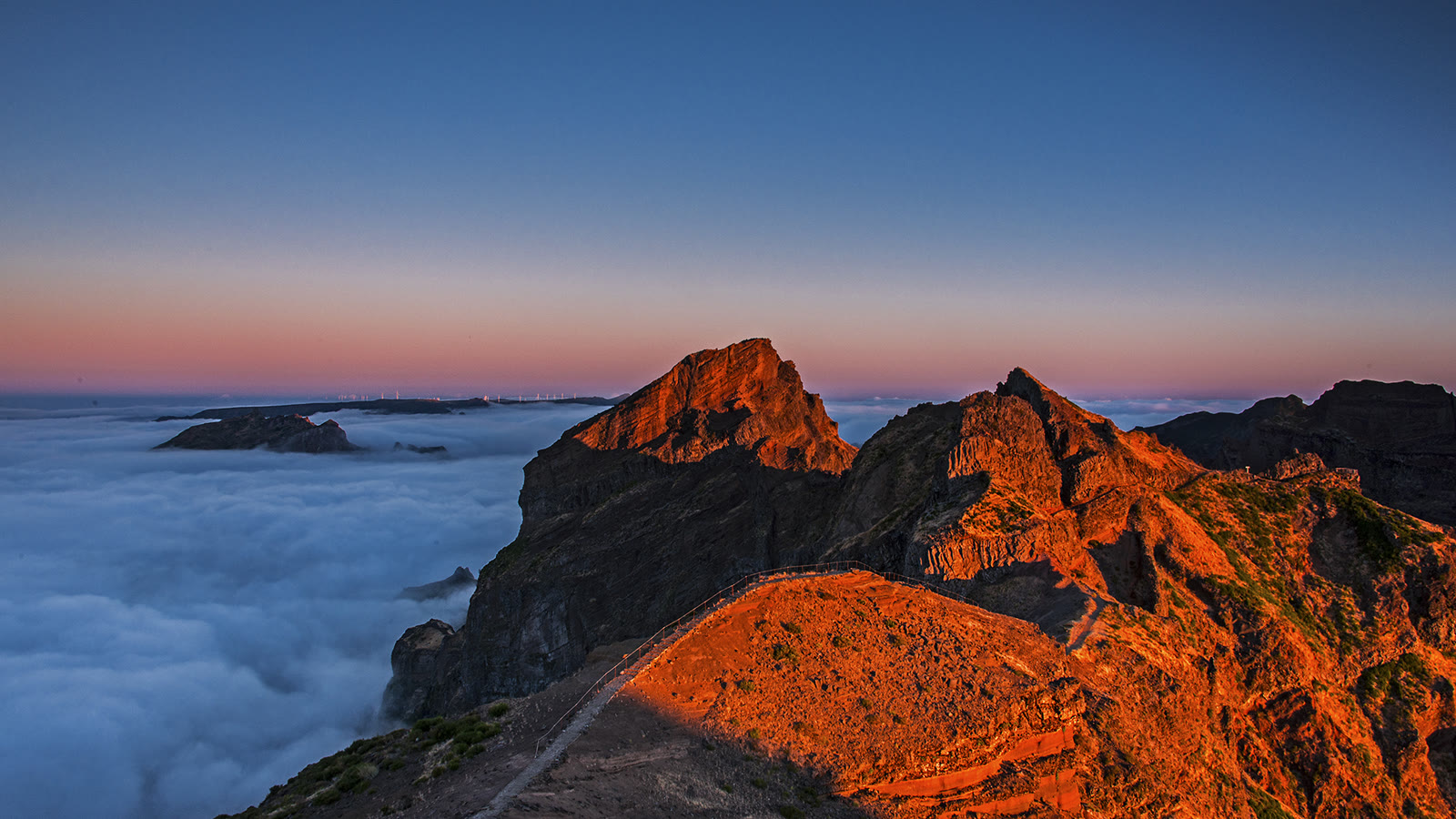 Bjergkammen ved Pico do Arieiro på Madeira i solopgang med stien og et skyhav nedenfor